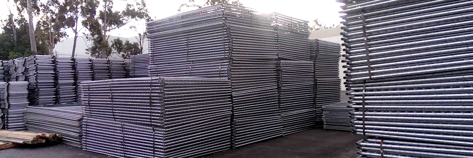 Temporary Fence Panels are stacked in semi-high piles and delievered to an event or construction site by a large truck.