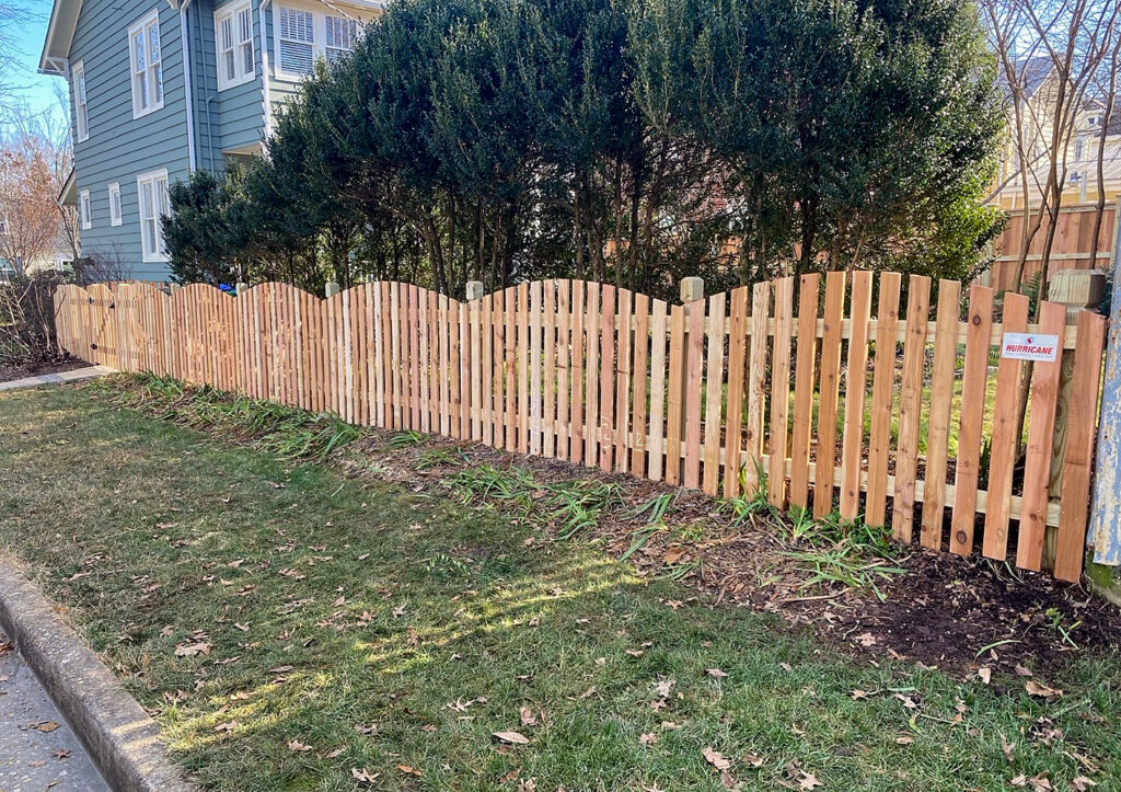 Convex top wooden fence installed by Hurricane Fence Company in a residential neighborhood.