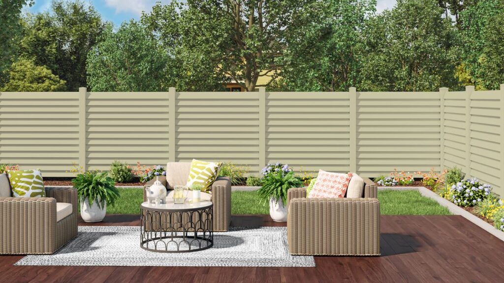a vinyl privacy fence in a clean cut backyard with nice outdoor patio furniture, some grass, and other chic decor.