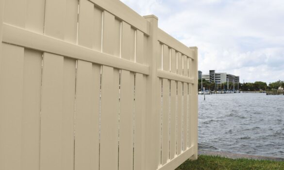 A vinyl privacy fence going down a yard in a coastal environment.