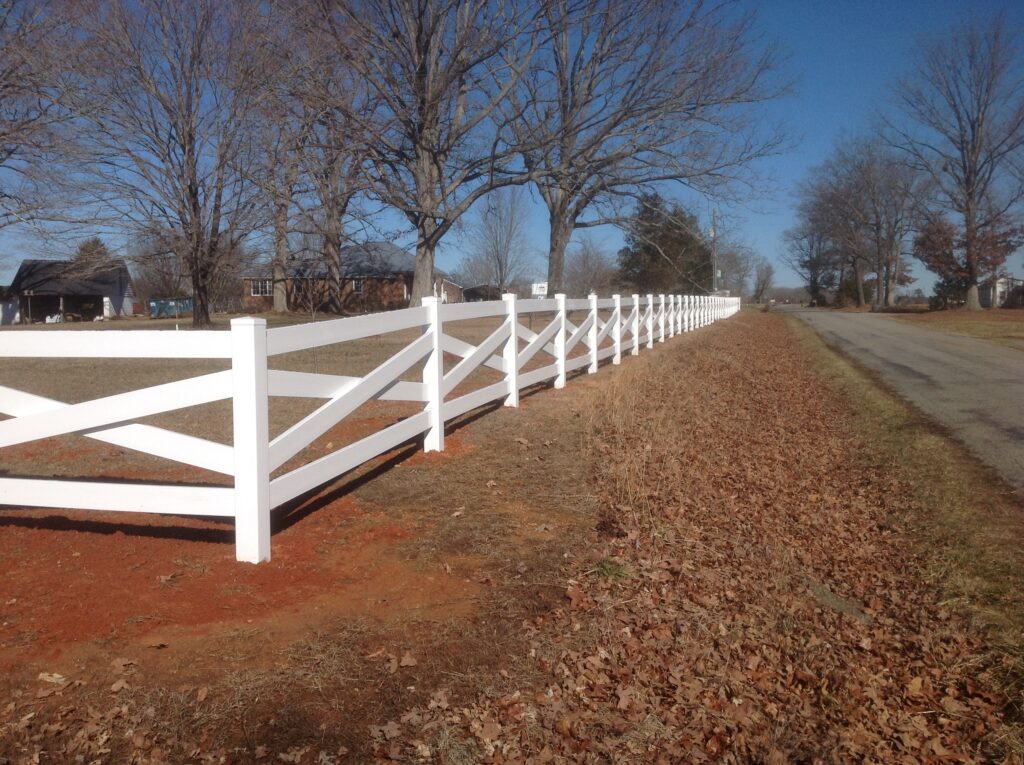 white vinyl fencing on a rural residential property in a crossbuck style